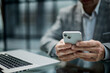 © ASDF - Man in business attire holds smartphone with focused attention