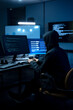 © Velocitystock777 - Male computer hacker in black hoodie typing code on computer in a dark room with light reflection on glasses.