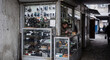 © Alexandr - Street electronics repair kiosk in a weathered urban passage, Eastern Europe editorial-like