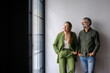 © Johnér - Full length of happy male and female business coworkers looking away while standing with hands in pockets at new office