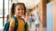 © Eve - Portrait of happy smiling young Black schoolgirl with backpack holding notebook in school corridor classmate blurred back to school concept background