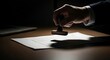 © Barca - Hand stamping a legal contract document in dramatic lighting