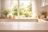 Softly blurred kitchen space with summer window view and smooth bleached wood counter