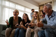 © Nenad - Kids gaming on console with grandparents cheering in living room