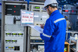 © reewungjunerr - Electrical engineer male checking voltage at the Power Distribution Cabinet in the control room,preventive maintenance Yearly,inspecting power system and control panel in industrial factory