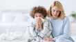 © OleksandrZastrozhnov - Child sneezing into tissue while mother comforts in bedroom
