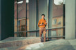 © ivanko80 - Young professional woman walking outside modern office building with smartphone and coffee cup