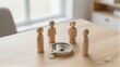 © YiuCheung - Four wooden figures gather around a compass on a table symbolizing