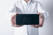 © Artvibe - Businessman holding smartphone with blank screen on white background. Mock up