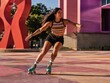 © Hoolity - A woman roller skating outdoors in colorful attire during daytime, with dynamic movement and a modern urban backdrop.