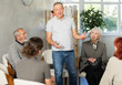 © JackF - Engaged senior man standing and sharing his opinion during an interactive group meeting