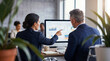 © Pamela - Professional business colleagues collaborating and analyzing data on a computer screen in a contemporary office.