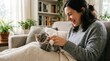 © FACTORY GRAPHICA  - Smiling Young Woman Playing with Gray Kitten on Cozy Living Room Sofa