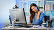 © Phushutter - Young office worker at desk massaging sore neck while using computer in modern workplace, suggesting stress, fatigue, or ergonomic pain.