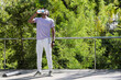 © wavebreak3 - Adult African American man drinking from clear bottle on wooden-deck in purple tee near black mat