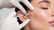 © Rhony - Close-up of a woman receiving facial injections from a medical professional at a clinic.