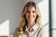 © Pete - Smiling blonde businesswoman poses in studio. She has bright blue eyes and light colored shirt. Natural window light illuminates her face, creating soft shadows.