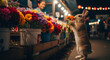 © BLHDNG - A cute rabbit stands on its hind legs, sniffing an orange flower at a vibrant night flower market with a smiling vendor in the background.
