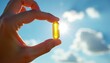 © Viktor - Hand holds golden fish oil capsule against bright blue sky. Sunlight shines through supplement. Represents health boost, wellness routine, preventative care. Ideal for nutrition ads medical content.