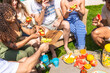 © unai - Diverse friends enjoying outdoor healthy picnic in summer garden