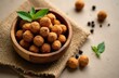 © Viktor - Wooden bowl holds fluffy orange Makhana seeds. They are a light, healthy snack. Some seeds lay scattered around. Basil leaves add freshness to the composition.