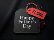 © TFU - Happy father's day 21 june message displayed prominently on black and red tags with a red string and small ribbon curl on a dark textured background, signifying