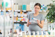 © JackF - Attentive young pregnant girl buyer choosing medical ointment in small pharmacy
