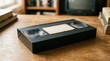 © Valentyna - VHS cassette on a table for retro video recording and vintage analog film entertainment. Old technology media, plastic tape