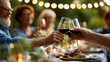 © Laura - Adults toasting with wine glasses around a beautifully served outdoor table during a family dinner gathering, celebration and togetherness concept, summer evening dining,
