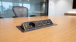 © Sekai - Modern close up of integrated desktop connection hub featuring universal power sockets and data outlets