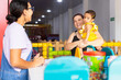 © Carlostock - Two adult women and a baby sharing a welcoming moment at a childcare center, reflecting trust, care and family support, Latina women and baby 1 to 2 years old.