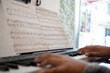 © JCarlos VBrito - Teenager practicing piano keyboard with sheet music, learning musical instrument