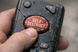 © Fotograf - A person holds a remote control with a focused expression