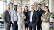 © Kowit - A diverse, professional group of seven smiling businesspeople standing confidently in a modern office setting.