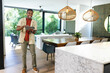 © wavebreak3 - African American male standing and using tablet in open-plan home near glass doors, copy space