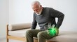 © Flash memory - Senior man touching his painful hip while sitting on a medical couch. Highlighted joint anatomy showing injury or condition. Healthcare and orthopedic concept for treatment and diagnosis.