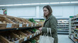 © Friedbert - Shopper concerned about food supply and climate pressure in a grocery aisle