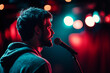 © Tetiana - Stand-up comedian performing live on stage with microphone, vibrant concert ambiance created with generative AI
