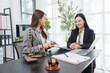© Kritdanai - Legal Consultation: Two professional women, one a lawyer with scales of justice and gavel, discuss a case with a client at a desk in a bright, modern office, fostering trust and legal guidance.