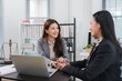© Kritdanai - Legal Consultation: Two professional women, one a lawyer and the other a client, engage in a focused and empathetic consultation, holding hands for reassurance in an office setting.