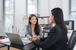 © Kritdanai - Professional Consultation: Two female lawyers engage in a constructive meeting in a bright, modern office, discussing a case with attentive smiles and focused gazes.