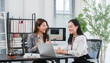 © Kritdanai - Legal Consultation: Two professional women, one a lawyer and the other a client, engage in a discussion at a desk in a bright office, surrounded by legal books and professional attire.