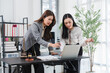 © Kritdanai - Legal Collaboration in Action: Two focused female lawyers intently discuss a case, analyzing documents and a laptop screen, with law books and a gavel nearby, signifying their professional dedication.