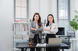 © Kritdanai - Lawyer Partnership in Office: Two confident female lawyers stand with arms crossed in a modern office setting, surrounded by legal books, a laptop, and scales of justice.