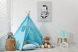 © New Africa - Wigwam, toys, small chair and pillows near white wall in child's room