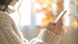 © pumpupin - 健康アプリを片手でスクロールする日本人・リビング室内・顔なし胸元構図 / Japanese Person One-Hand Scrolling Health Wellness App — Chest-Up Frame, Face Excluded, Soft Living Room Bokeh, Healthcare Digital Lifestyle, Natural Light