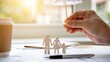 © Arnab Dey - Life insurance concept showing family protection with wooden figures under umbrella on financial documents. Represents coverage, beneficiaries, income security, financial planning.
