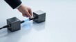 © Giggles - Corporate hand connecting glowing blue fiber optic cable between dark metallic blocks on light surface with empty copy space for data transfer technology header