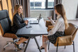 © undrey - Young businesswoman conducting a job interview with a prospective female employee, sharing a discussion about career opportunities in a modern office setting