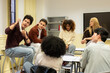 © Ladanifer - Multiethnic high school students working together, learning, and conversing in a modern classroom setting